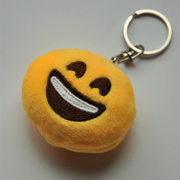 Emojinyckelring som är glad och leende